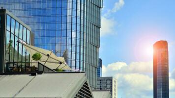 Glass modern building with blue sky background. View and architecture details. Urban abstract - windows of glass office building in  sunlight day. photo