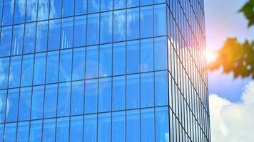 Structural glass wall reflecting blue sky. Abstract modern architecture fragment. Glass building with transparent facade of the building and blue sky. Contemporary architectural background. photo