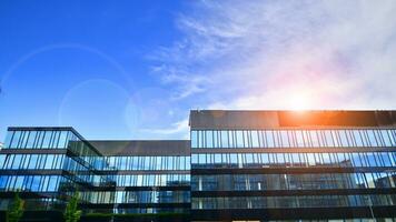 Structural glass wall reflecting blue sky. Abstract modern architecture fragment. Glass building with transparent facade of the building and blue sky. Contemporary architectural background. photo