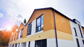 New single family houses in a new development area. Residential homes with modern facade. Terraced family homes in newly developed housing estate. The real estate market in the suburbs. photo