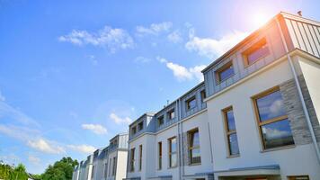 New single family houses in a new development area. Residential homes with modern facade. Terraced family homes in newly developed housing estate. The real estate market in the suburbs. photo