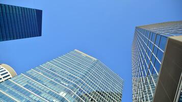 Modern office building with glass facade on a clear sky background. Transparent glass wall of office building. photo