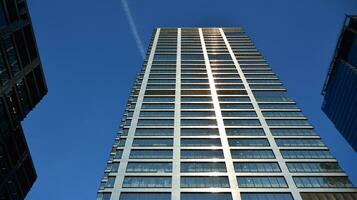 Modern office building with glass facade on a clear sky background. Transparent glass wall of office building. photo