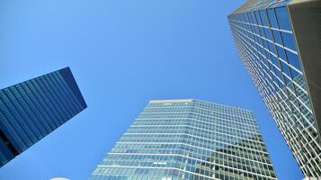 Modern office building with glass facade on a clear sky background. Transparent glass wall of office building. photo