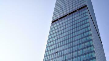 moderno oficina edificio con vaso fachada en un claro cielo antecedentes. transparente vaso pared de oficina edificio. foto