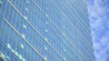 Abstract fragment of contemporary architecture, walls made of glass and concrete. Abstract closeup of the glass-clad facade of a modern building covered in reflective plate glass. photo