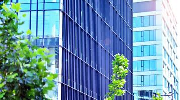 Eco architecture. Details of facade glass and aluminum panels on  building. Green tree and modern office building. The harmony of nature and modernity. photo