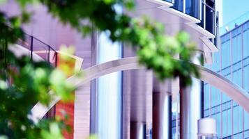 Eco architecture. Details of facade glass and aluminum panels on  building. Green tree and modern office building. The harmony of nature and modernity. photo