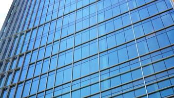 Abstract fragment of contemporary architecture, walls made of glass and concrete. Abstract closeup of the glass-clad facade of a modern building covered in reflective plate glass. photo