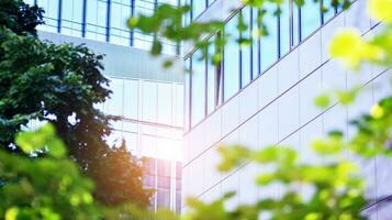 Eco architecture. Details of facade glass and aluminum panels on  building. Green tree and modern office building. The harmony of nature and modernity. photo