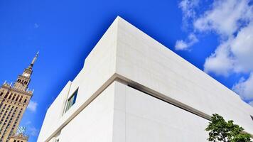 Modern white concrete building walls against blue sky. photo