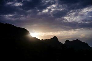 The first light of day rises between the mountains. photo