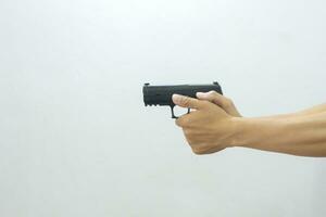Man holding gun with both hands aiming forward on white background photo