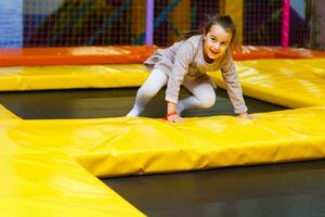 Little pretty girl is having fun outdoor. Playing in children zone in amusement park. photo