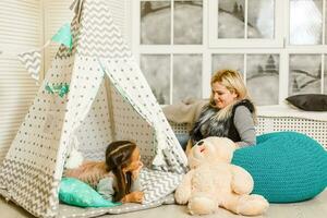 girls playing together at home with toys in children wigwam. Friendship, childhood, happiness concept photo
