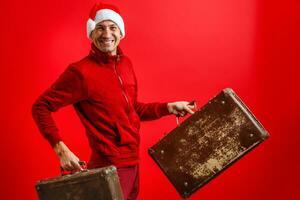 Christmas, tourist trip concept. Santa Claus with suitcases is going to travel around the planet. Christmas time. Time for miracles. Copy space. photo