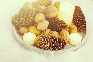 Christmas candles, wood slice decorations, pine cone on white background photo