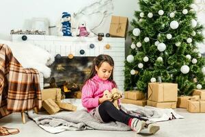 Portrait of pretty little girl near a fireplace in Christmas photo