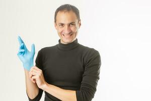 hombre poniéndose guantes quirúrgicos de látex foto