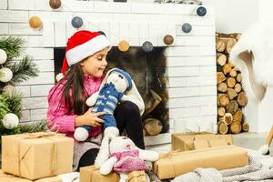 Portrait of pretty little girl near a fireplace in Christmas photo