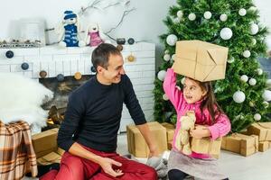 alegre Navidad y contento vacaciones. familia preparación cerca el Navidad árbol a hogar foto