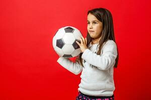 Little girl with the ball over red backgrounf photo