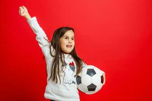 pequeño joven niña con fútbol pelota en mano sonriente en cámara aislado en blanco antecedentes foto