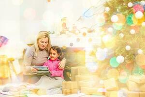 madre y hija abrazando cerca Navidad árbol foto