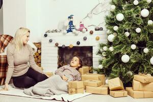 Happy mother and little daughter decorating christmas tree at home photo