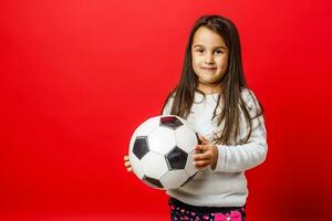 pequeño niña con el pelota terminado rojo fondo foto