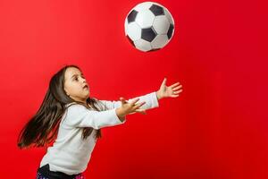 Little girl with the ball over red backgrounf photo