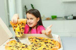 little girl with big pizza at home photo