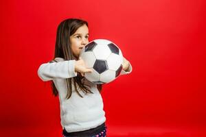 Little girl with the ball over red backgrounf photo