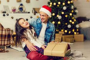 Family, christmas, x-mas, happiness and people concept - smiling father and daughter holding gift box photo