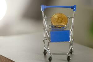 Shop trolley for purchases with bitcoins. Crypto currency bitcoin on a black background. Empty space for text. photo