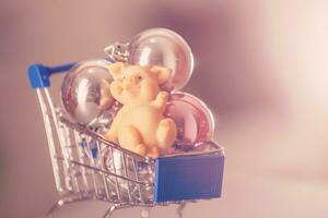 The symbol of the year 2019 is a pig with gifts in a shopping trolley close-up. photo