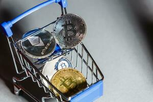 Shop trolley for purchases with bitcoins. Crypto currency bitcoin on a black background. Empty space for text. photo