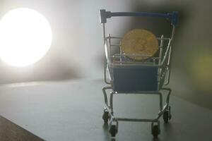 Shop trolley for purchases with bitcoins. Crypto currency bitcoin on a black background. Empty space for text. photo