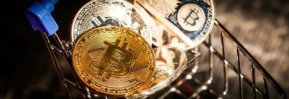 Shop trolley for purchases with bitcoins. Crypto currency bitcoin on a black background. Empty space for text. photo