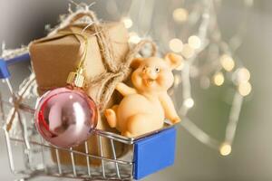 The symbol of the year 2019 is a pig with gifts in a shopping trolley close-up. photo