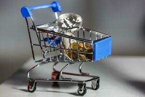 Shop trolley for purchases with bitcoins. Crypto currency bitcoin on a black background. Empty space for text. photo