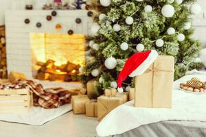 New Year's gifts under the Christmas tree. The gifts are packed in kraft paper and tied photo