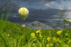 Flying hot-air balloon over the grass field, 3d rendering. photo