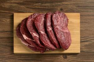 Raw beef with wooden table background photo