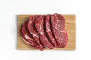 Freshness raw beef in pieces on the cutting board with white background. photo