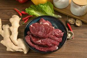 Raw beef with wooden table background photo