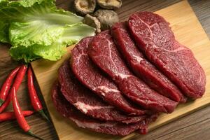 Raw beef with wooden table background photo