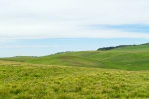 Grassland and mountains in a cloudy day. Photo in Kalajun grassland in Xinjiang, China.