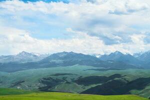 Grassland and mountains in a cloudy day. Photo in Kalajun grassland in Xinjiang, China.