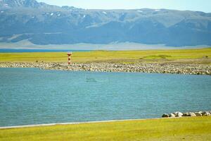 Road and lighthouses on the lake. Shot in Sayram Lake in Xinjiang, China. photo